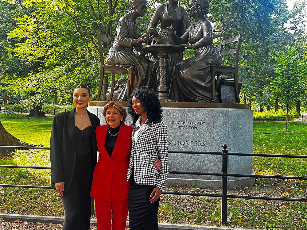 Veronika Didusenko, Gloria Allred, and Danielle Hazel in front of the Women's Rights Pioneers Monument in Central Park